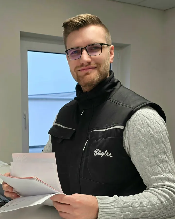 Herr Peter im Büro, mit Unterlagen in der Hand