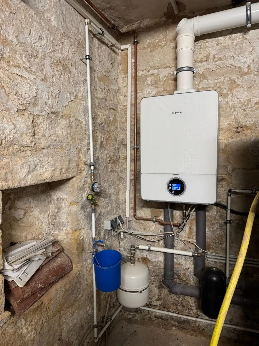 Wandhängendes Bosch-Gas-Brennwertgerät in einem Kellerraum mit Natursteinwand; Gas-Brennwertheizung in Neustadt an der Weinstraße