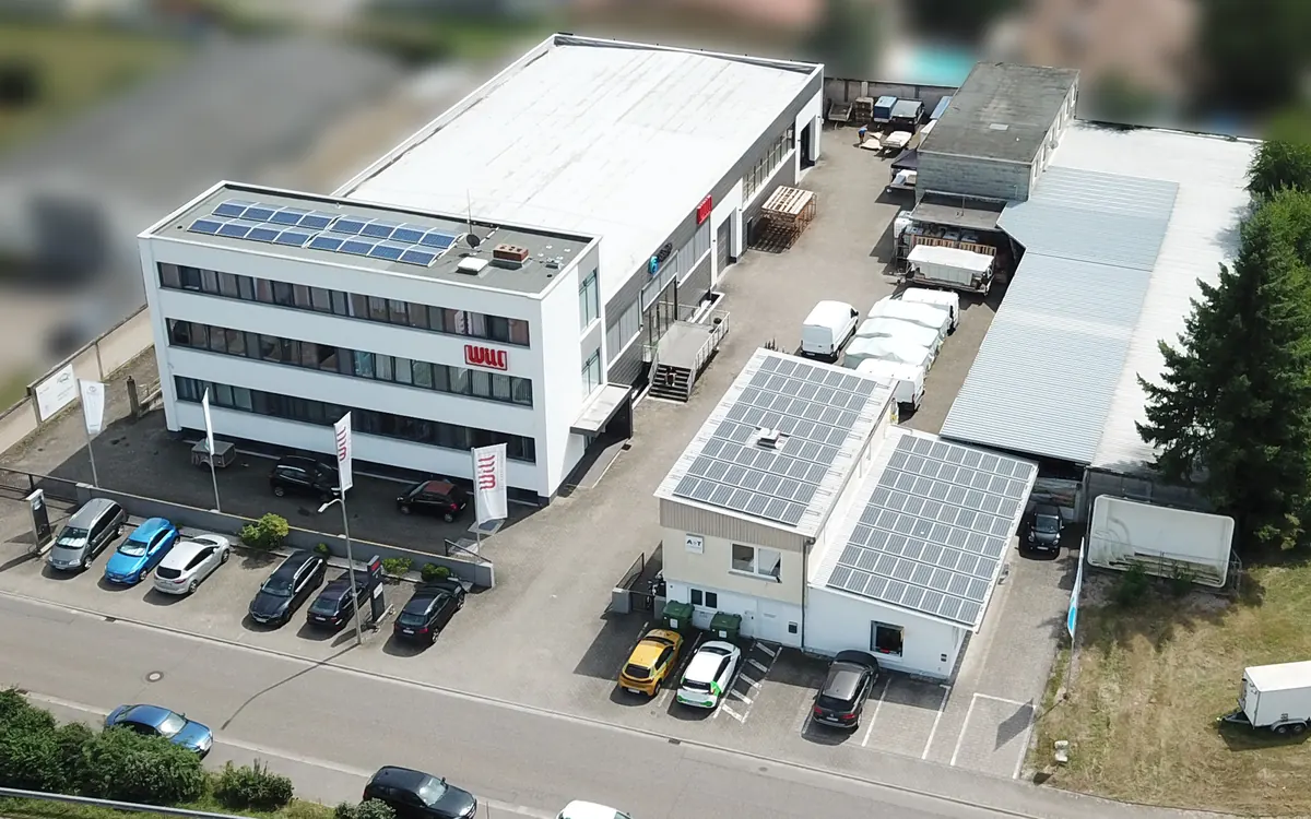 Luftaufnahme des Betriebssitzes von WILL Bad Wärme Energie in Bellheim: Bürogebäude mit WILL-Schriftzug, Halle und Nebengebäude mit Photovoltaik auf den Dächern